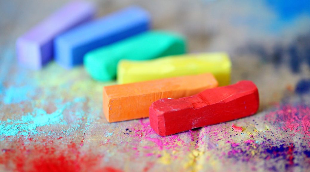 assorted colored chalks on wood surface