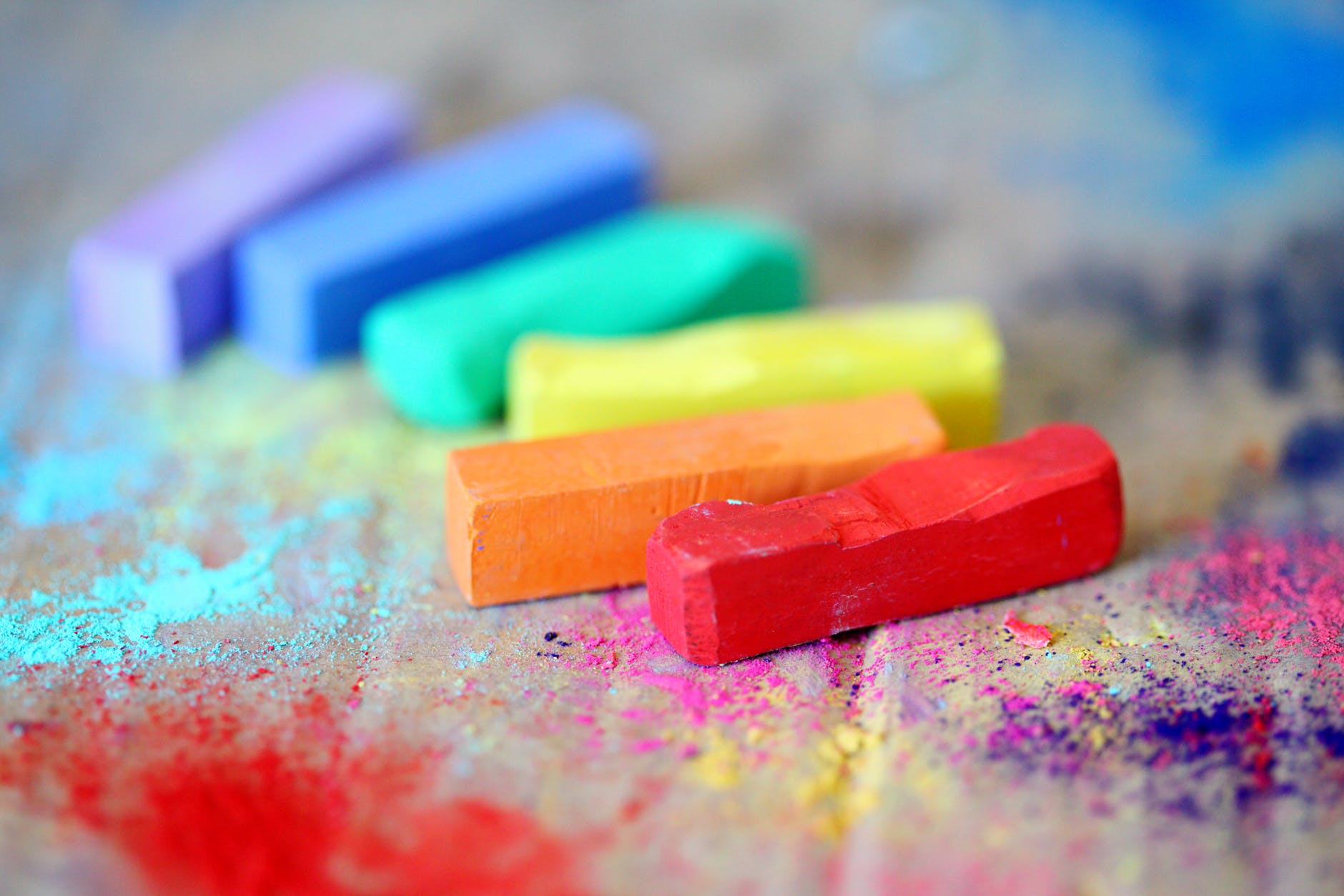 assorted colored chalks on wood surface